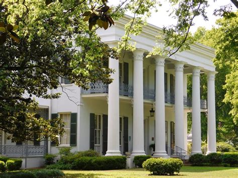 A Large White House With Columns On The Front