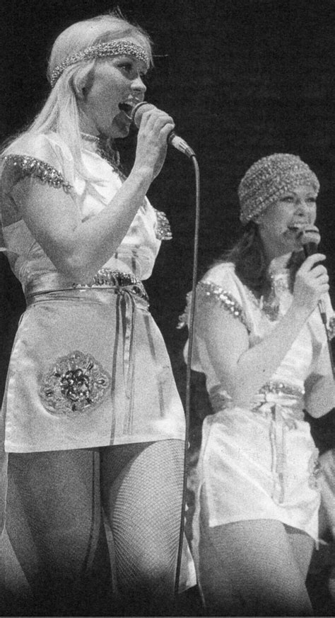 Two Women Singing Into Microphones While Standing Next To Each Other