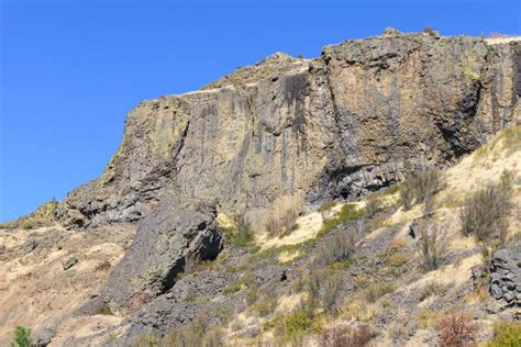 Basalt Cliff Face Rises Above A Dry Slope In Central Washington Stock