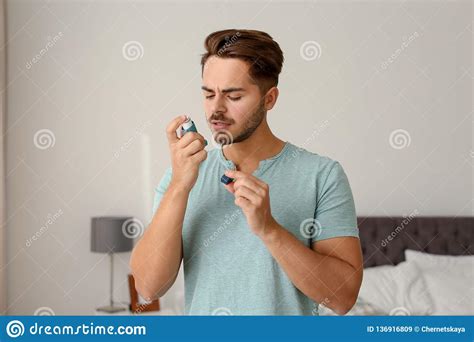 Hombre Joven Que Usa El Inhalador Del Asma Imagen De Archivo Imagen