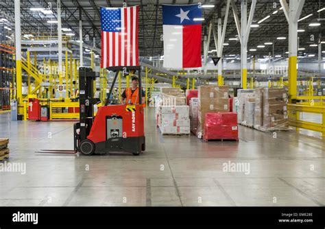 Male Amazon employee drives forklift at warehouse in Texas Stock Photo ...