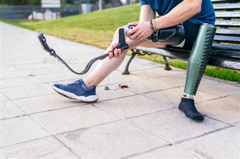 Sportive Man Tuning His Carbon Fiber Prosthetic Leg In The Park Stock