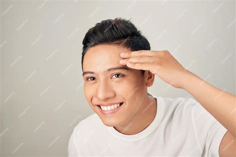 Hombre Guapo Tocando Su Rostro Cerca De Estudio De Retrato Sobre Fondo