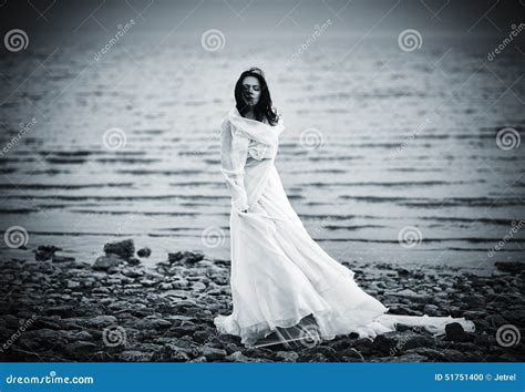 Belle Fille Triste Dans La Robe Blanche Se Tenant Sur La Côte Photo