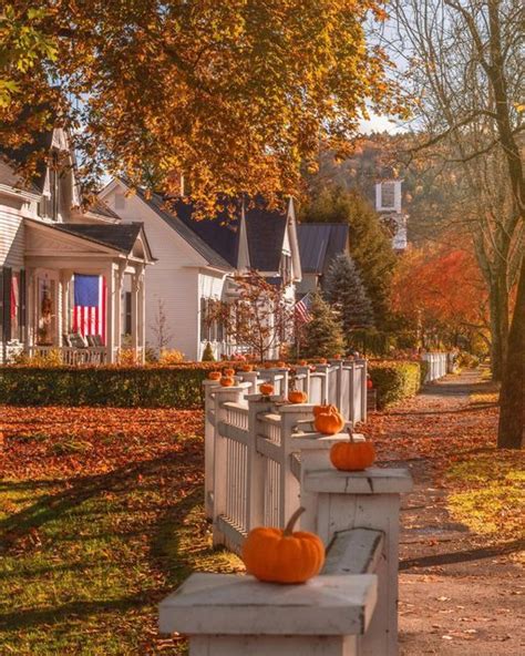 Several Pumpkins Are Sitting On The Fence In Front Of A House With An