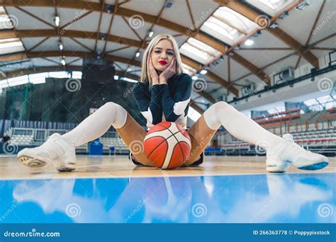 Cheerleader Sitting On The Floor With Legs Spread And A Basketball