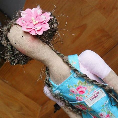 The Doll Is Wearing A Blue Dress With Pink Flowers On It S Head And Hair