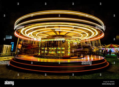 Carousel Spinning With Coloured Lights At Night Stock Photo Alamy