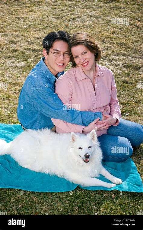 Young Married Couple Asian Man With Glasses And Pregnant Caucasian