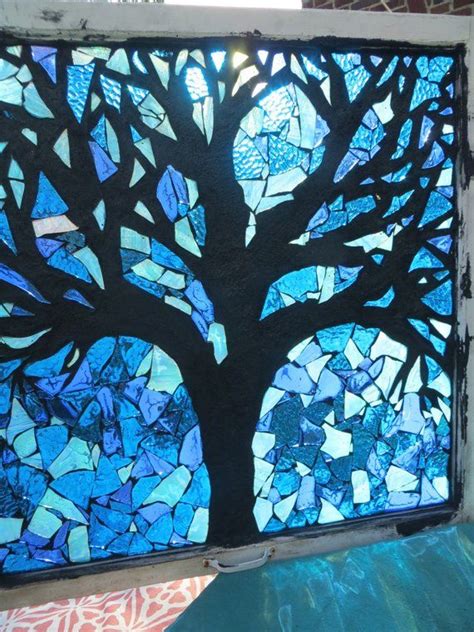 A Stained Glass Window With A Tree In The Center And Blue Leaves On It