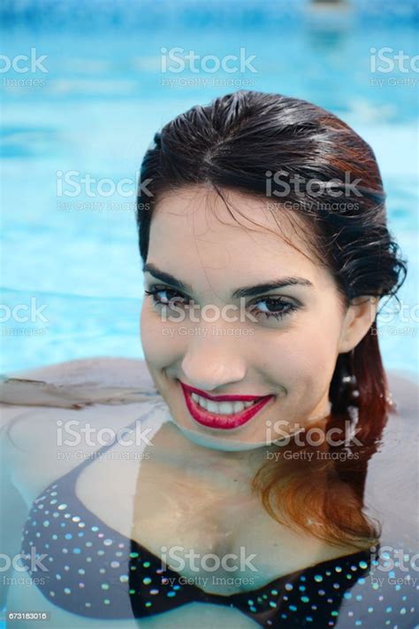 Beautiful Young Woman Relaxing In Water By The Swimming Pool Stock