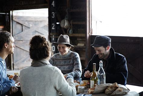 Group Of Friends Having A Rustic Farm To Table Picnic In Wood Barn By