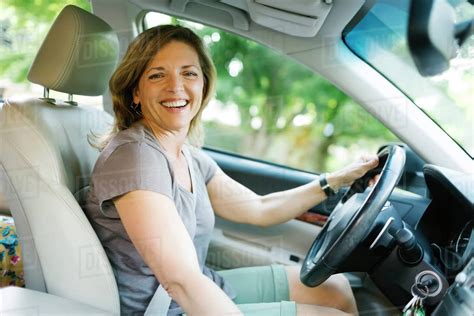 Portrait of smiling woman driving car - Stock Photo - Dissolve