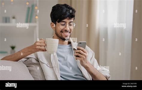 Millennial Arabic Guy Indian Handsome S Man Sitting At Home On Couch Drinking Hot Tea Coffee