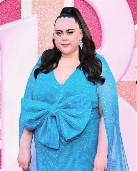 A Woman In A Blue Dress With A Big Bow On Her Shoulder