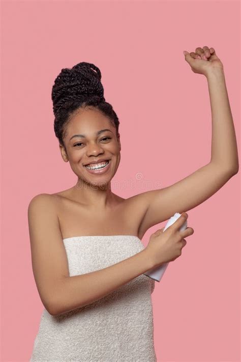 Dark Skinned Young Woman Spraying Deodorant On Her Body After Shower