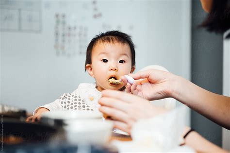 Mother Feeding Food At Home By Stocksy Contributor Maahoo Stocksy