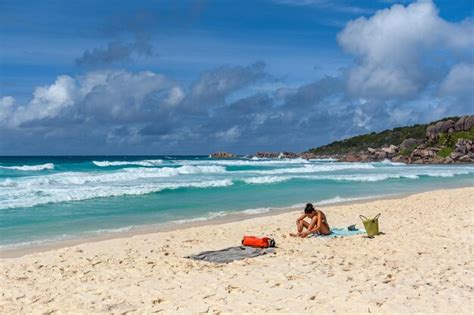 Mujer con bikini relajándose y tomando el sol en una toalla en una