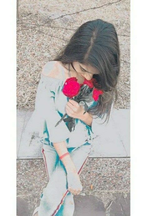 A Woman Holding A Red Rose In Her Right Hand And Looking Down At The Ground