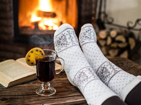 Warming And Relaxing Near Fireplace With A Cup Of Hot Wine And A Book