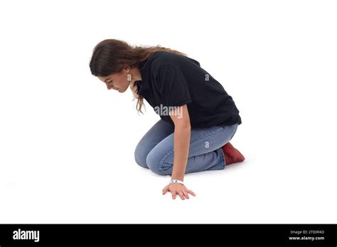 Side View A Young Girl Who Is On Her Knees On The Floor Looking For Something On A White