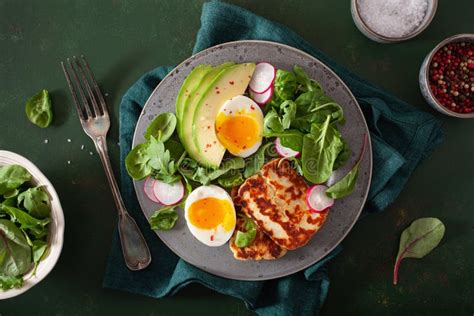 Healthy Keto Paleo Diet Breakfast Boiled Egg Avocado Halloumi Cheese Salad Leaves Stock