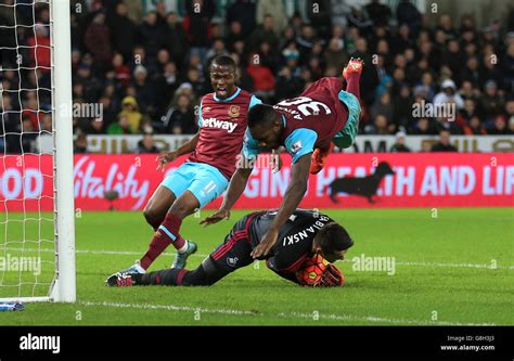 Swansea City goalkeeper Lukasz Fabianski saves at the feet of West Ham United's Mikail Antonio ...