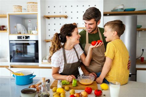 Familia Feliz En La Cocina Divirtiéndose Y Cocinando Juntos Imagen de