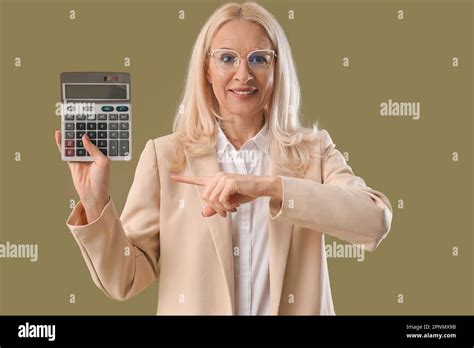 Mature Woman Pointing At Calculator On Green Background Stock Photo Alamy