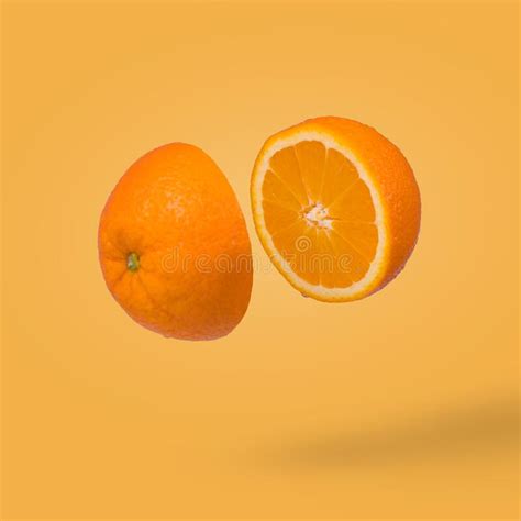 Minimal Idea With Juicy Orange Cut In Two Halves Flying In The Air