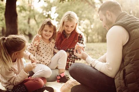 Familia Alegre En El Parque Que Tiene Comida Campestre Foto De Archivo