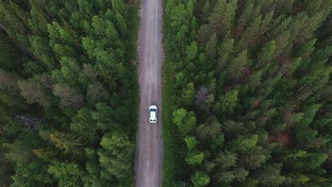 Aerial View Of White Car Driving On Country Road In Forest Cinematic