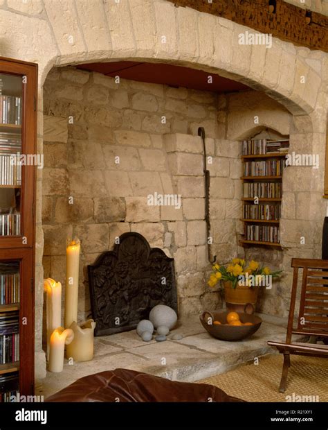 Tall lighted candles in inglenook fireplace Stock Photo - Alamy