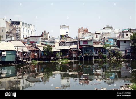 Old Houses On Stilts In The Slums Of Saigon Along A River Full Of Trash