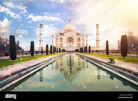 Taj Mahal tumba con reflejo en el agua en azul cielo dramático en Agra