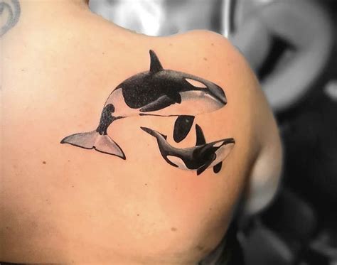 An Orca Whale Tattoo On The Back Of A Womans Upper Arm And Shoulder