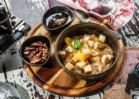 Oatmeal Porridge With Pieces Of Fruit Nuts And Honey In Bowl On Wooden