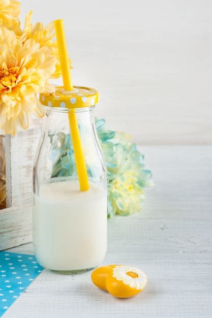 Botella de leche con pajita y corazón amarillo Foto Premium