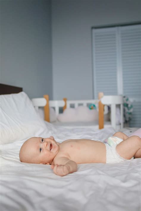 Baby In White Diaper Lying On Bed · Free Stock Photo