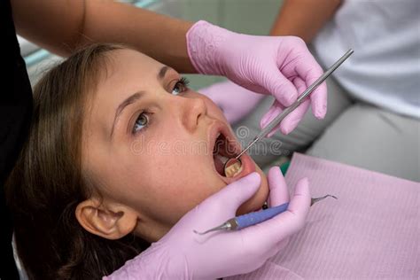 Dentist Examines The Oral Cavity Of Patient In Clinic Stock Photo