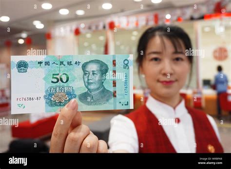 A Chinese Employee Shows A Yuan Banknote Of The Edition Of The