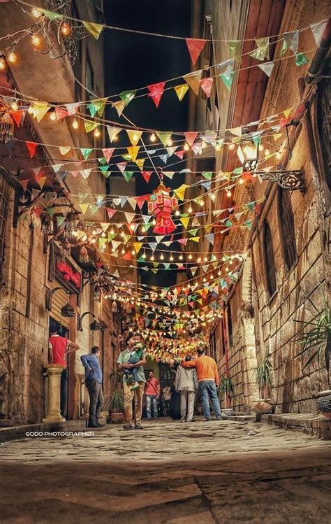 Several People Are Walking Down An Alley Way With Colorful Lights