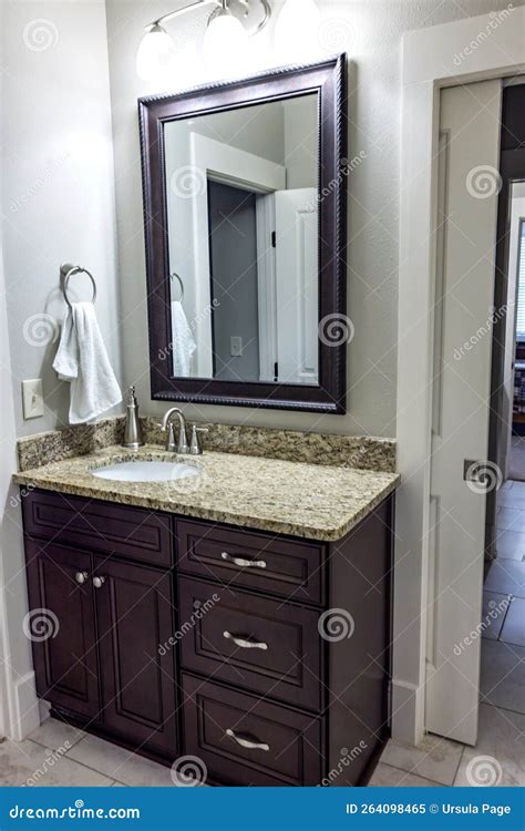 A Dark Wood Stained Bathroom Vanity With A Granite Countertop And Mirror Stock Image Image Of