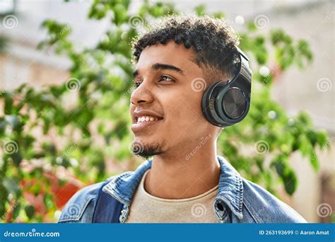 Hispanic Young Man Listening To Music Wearing Headphones At The Street