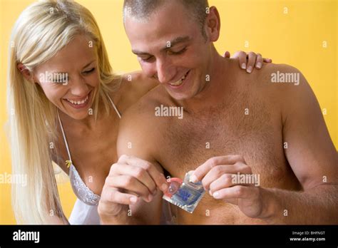 Couple Practicing Safe Sex By Using A Condom Barrier Device Before