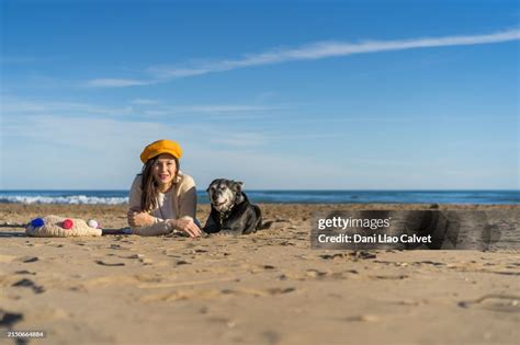 老犬と砂浜に横たわる女性 ストックフォト Getty Images