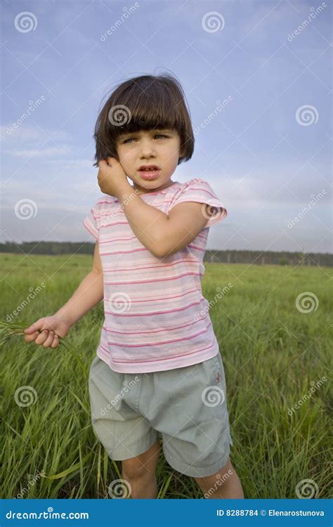 Bambina Con Erba Che Si Leva In Piedi Sul Prato Fotografia Stock