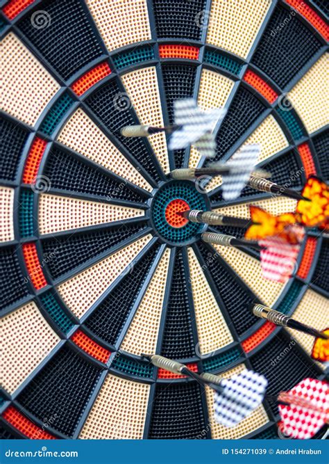 Picture Of Darts Arrow Hitting In The Target Center Of Dartboard