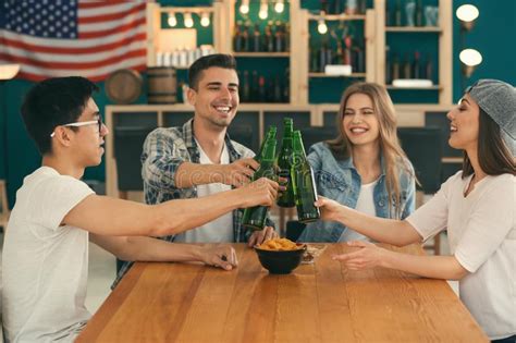 Grupo De Amigos Alegres Que Beben La Cerveza En Barra Foto De Archivo