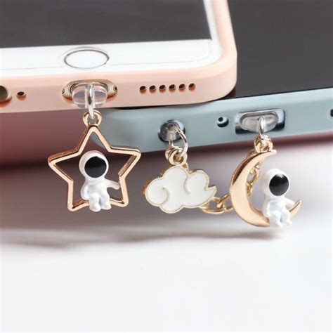 Three Charms That Are Attached To A Cell Phone